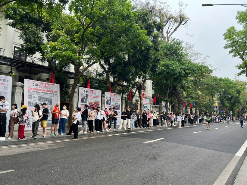 Sáng 30/4, hàng dài người xếp hàng nhận phụ san 30/4 của Báo Nhân Dân. (Ảnh: QUỲNH TRANG)